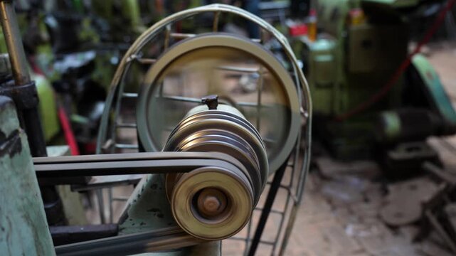View of a belt-driven pulley system rotating on industrial machinery in a workshop Kushtia, Khulna Division, Bangladesh.
