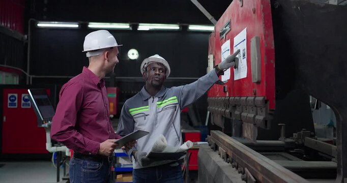 Sales Engineer Briefs Client on Machine Capabilities in Metal Workshop