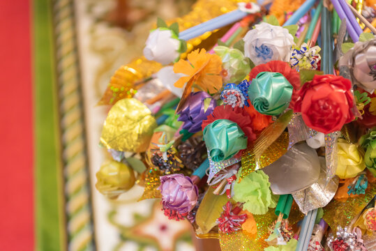 Colorful kathin money tree made from paper flowers sticks used for buddhist donation ceremony festive decoration vibrant handmade craft closeup detail