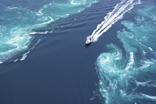 Powerboat between huge whirlpools and eddies in the water of a fjord, strongest tidal current in the world, Saltstraumen, Nordland, Kystriksveien, Bod&ouml;, Norway