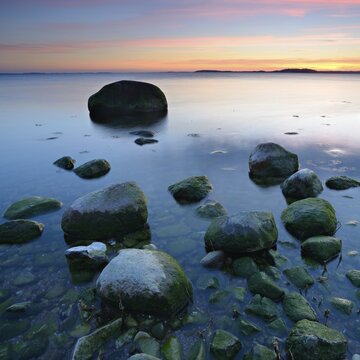 Sunset at the Baltic Sea, large erratic blocks, Greifswalder Bodden, peninsula M&ouml;nchgut, island R&uuml;gen, Mecklenburg-Western Pomerania, Germany