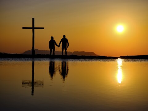 Couple next to summit cross at sunset, silhouette, reflection in the water, Trattberg, Bad Vigaun, Land Salzburg, Austria