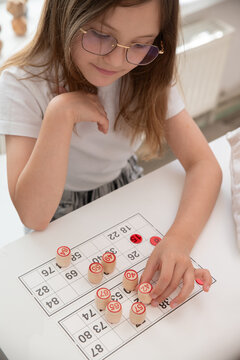 A real photograph of a girl and a woman playing bingo. A mother and daughter playing board games together. Real emotions, passion. Selective focus.
