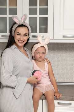 A beautiful adult woman and her daughter cleanse their faces at home, selective focus. Family and hygiene. Real photo.