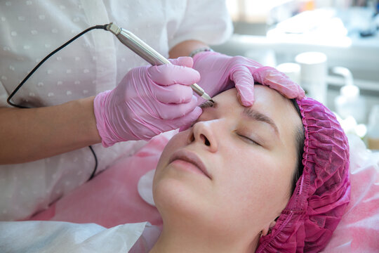 Permanent tattoo makeup procedure. Eyebrow tattoo make-up. Brow tattoo. Close up, selective focus