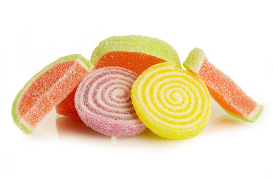 Assortment of sugar-coated jelly candies in spiral and fruit slice shapes. These sweet, multi-colored chewy treats are perfectly isolated on a clean white background.