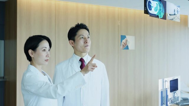 医療画面を見る男女医師のグループ