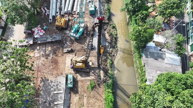 dredging mud on the riverbank in densely populated areas in the city center using heavy equipment such as excavators and dump trucks