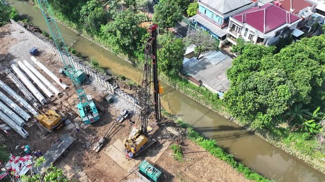 dredging mud on the riverbank in densely populated areas in the city center using heavy equipment such as excavators and dump trucks