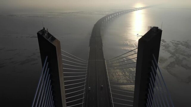 Aerial view of vasco da gama bridge over tagus river in lisbon during sunrise.