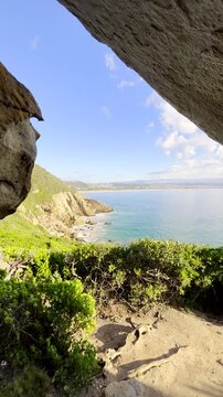 Cave view from Robberg circular hiking trail at sunrise in Plett. Vertical