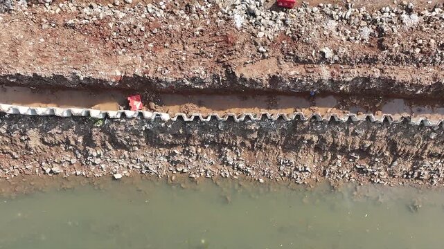 dredging mud on the riverbank in densely populated areas in the city center using heavy equipment such as excavators and dump trucks