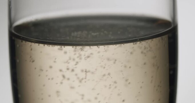 Thousands of sparkling bubbles rising in a champagne flute, a perfect symbol for celebration, success and luxury. This elegant, slow-motion footage is isolated on a clean white background.