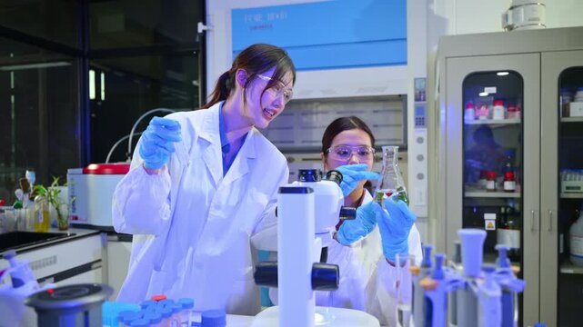 Female scientists conducting research using microscope in laboratory setting