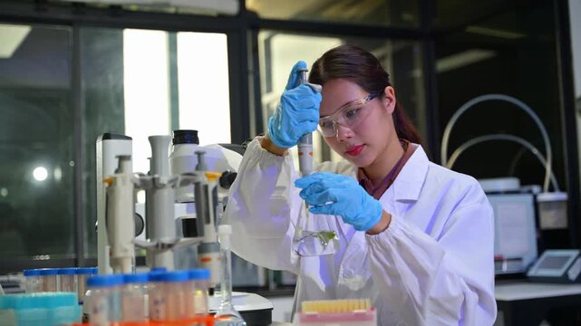 Female Scientist in Laboratory Using Test Tube with Laboratory Equipment and Safety Gear