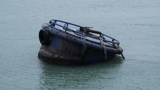 Large industrial steel mooring buoy floating in the sea near a shipping channel Xiamen, China. Concept of maritime infrastructure, port logistics, and commercial shipping operations.