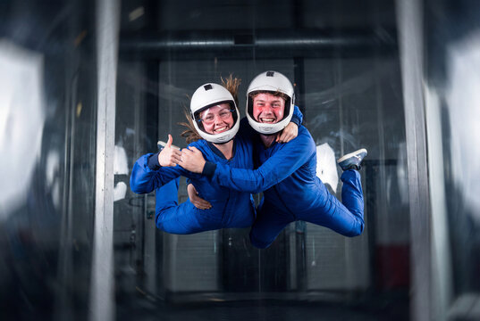 Happy young couple having fun during an indoor skydiving experience in a wind tunnel