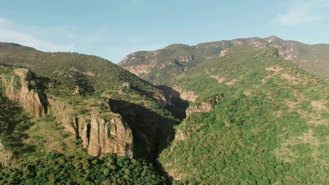 Aerial dolly in view of rocky canyon walls and green mountains in Ca&ntilde;&oacute;n de la Garita, Sierra Penjamo, Guanajuato