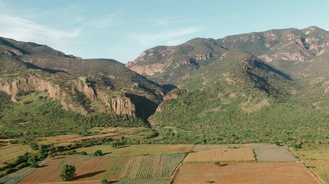 Garita canyon with steep rocky cliffs, green mountain slopes, dense vegetation, and cultivated agricultural fields near Sierra P&eacute;njamo, Guanajuato, Mexico.