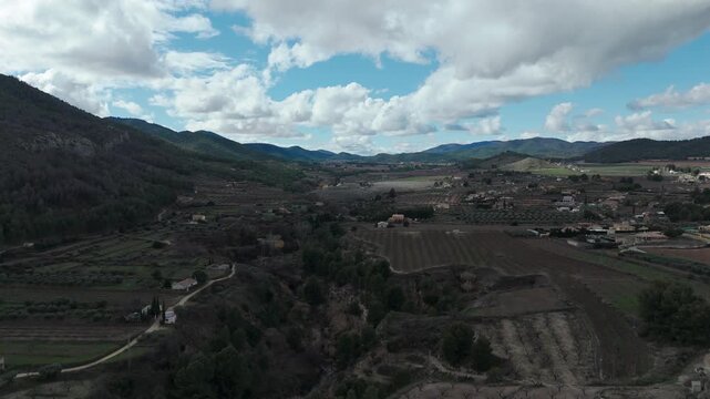 Drone footage showing Salto del Usero natural landscape with fields, farmhouse and distant mountain terrain near Bullas.