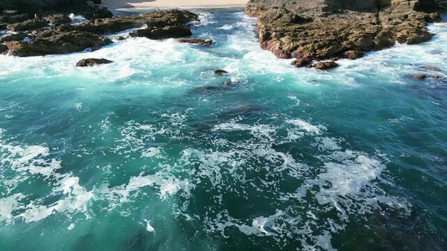 Aerial drone footage of Praia dos Buizinhos, Portugal: rugged Atlantic cliffs, ocean waves and natural coastal scenery under sunny light. Ideal for travel and nature projects.