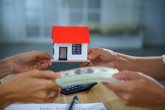 Real estate house model cash payment contract exchange office buyer seller show home purchase, mortgage loan approval, property sale closing on table with document, pen, calculator