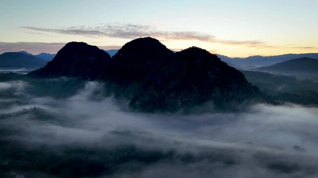 Drone Eye Level View of Twin Peaks Above Sea of Clouds at Golden Sunrise Meratus Mountains Borneo Indonesia