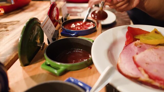 Person Scooping Barbecue Sauce Onto Roasted Meat at Buffet Lunch
