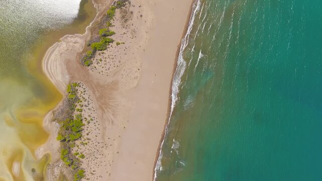 Dalyan, Turkey. Iztuzu Beach, a pristine sandbar between turquoise Mediterranean waters and golden river delta, aerial drone view on a sunlit summer day. Aerial View, HEAD OVER SHOT with rotation