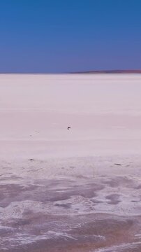 Vertical video. Aksaray, Turkey. Tuz Golu salt lake, vast white salt flats stretching endlessly to the horizon under a clear blue sky, aerial drone view with copy space. Aerial View. Rich colors
