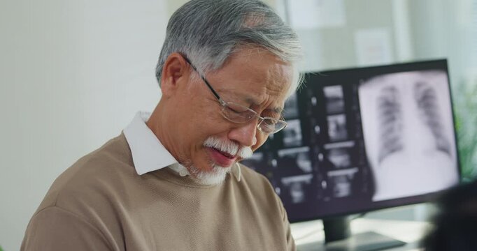 Young Asian female doctor examining senior man injured knee at hospital clinic. Physical therapy treatment, joint arthritis pain recovery, osteoarthritis medical care, physician consult concept.