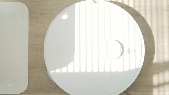 Robotic vacuum cleaner mopping wooden floor with sunlight, smart home appliance using automation for modern lifestyle.