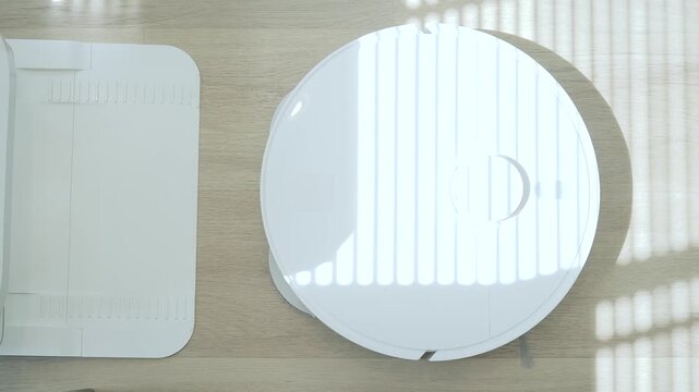 Smart robot vacuum back to station and cleaner on wooden floor in modern home, automated cleaning technology for convenient daily living.