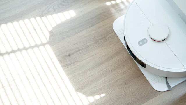 AI robot vacuum cleaner cleaning bright wooden floor, smart home technology for effortless household chores and floor care.