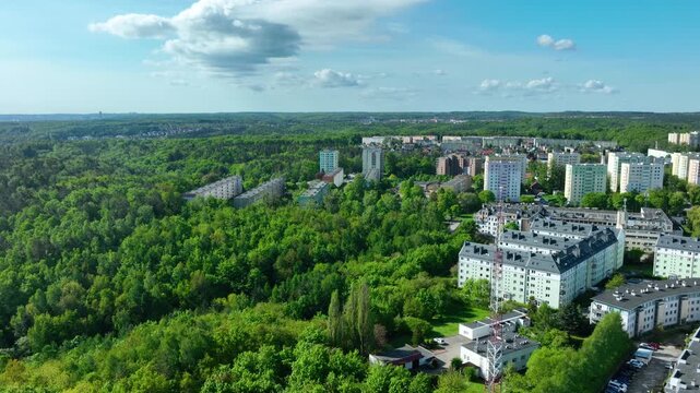 Cinematic aerial shot of urban apartment buildings integrated with nature in Gdynia, Poland. Highlighting ecofriendly urban planning and sustainability.