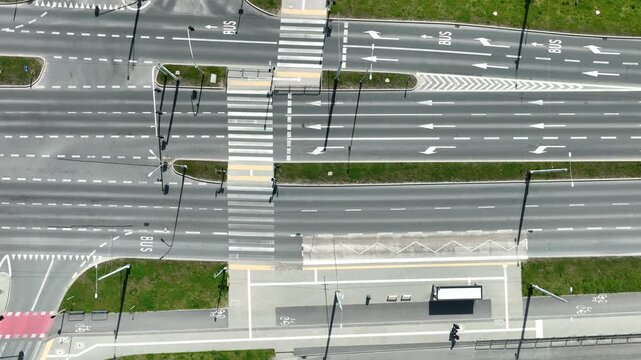 Cinematic top down aerial shot of a modern urban multilane highway with bus lanes and zebra crossings in Gdynia. Ideal for urban planning and smart city concepts.