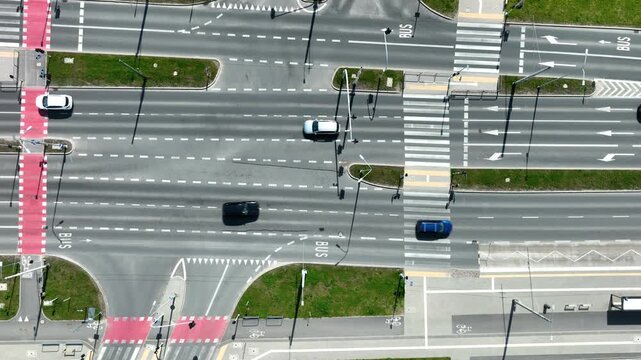 Cinematic topdown aerial shot of a busy city intersection with cars, pedestrian crosswalks, and bike lanes in Gdynia, Poland.