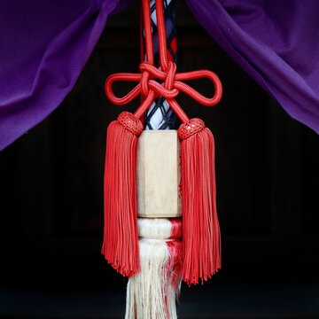 Ceremonial red silk tassels and knots on purple curtain at Kamigamo shrine, Kyoto, Japan