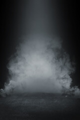 Fototapeta premium Dense white smoke billowing from a dark stage floor in dramatic lighting