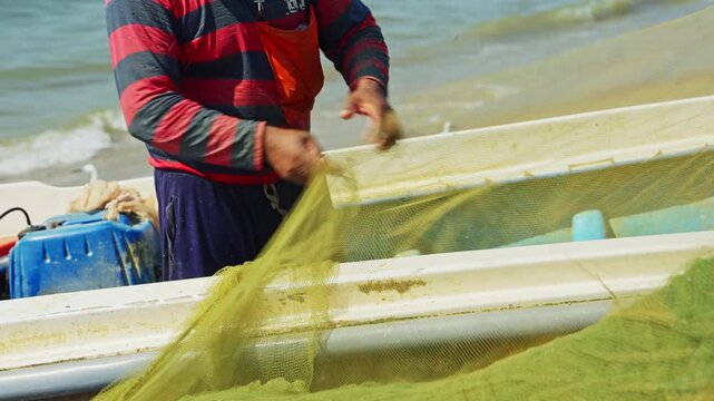 Fishermen working together on a Sri Lankan beach, gathering and managing fishing nets along the shoreline.