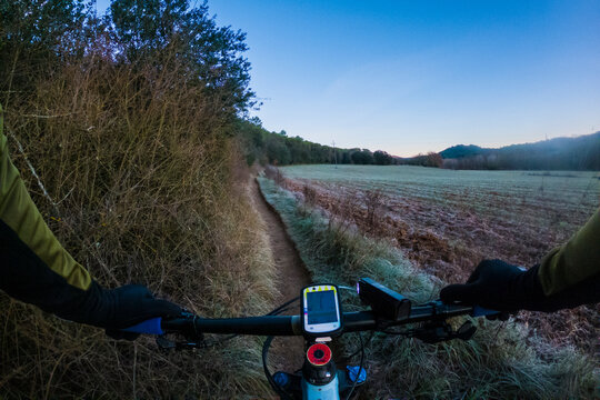 Riding a mountain bike chesty point of view on a cold and frozen winter path forest landscape