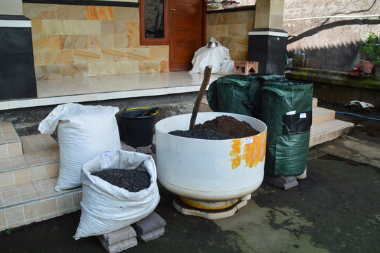 Elevated left angle image showing homemade potting soil preparation using fermented soil, rice husk charcoal, and mixing container on terrace area.