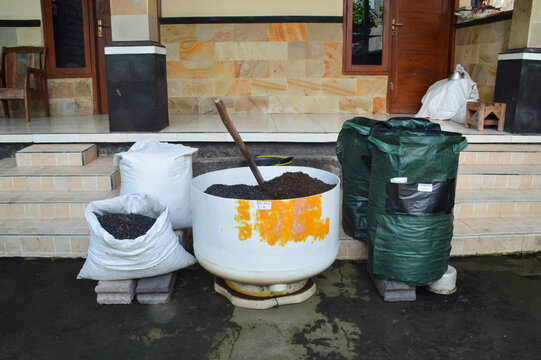 Center high angle view featuring soil mixing tub with planting media ingredients, charcoal husk stock, compost bags, and gardening tools outdoors.
