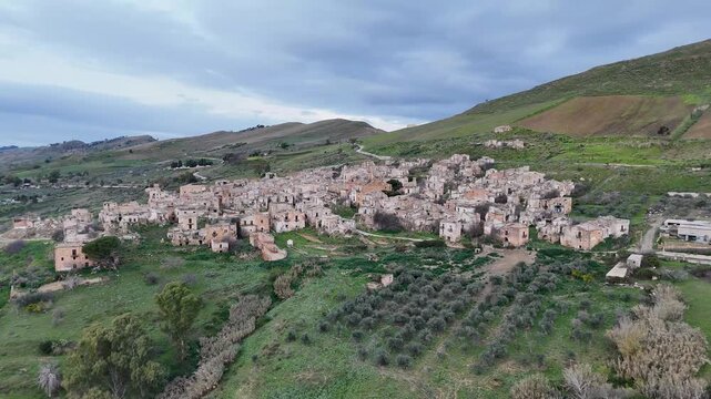 Drone view along an empty street through the abandoned hillside ruins of Poggioreale Vecchia in Sicily.