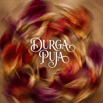 Abstract motion blur of colorful flower petals with Durga Puja text in the center
