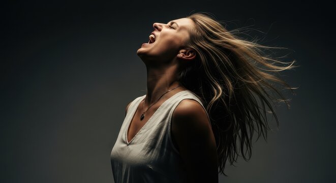 Passionate Young Woman Screaming with Long Blonde Hair Blowing in the Wind