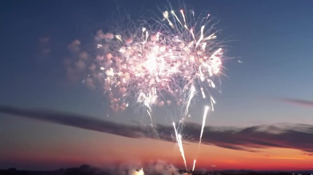 Dynamic, colorful fireworks explode across a stunning twilight sky with deep blues and soft oranges. High frame rate slow-motion, majestic bursts and shimmering trails, concept of grand achievements