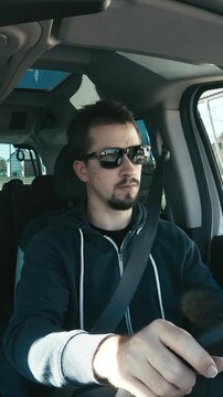 Male driver behind the wheel in car wide shot