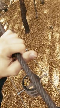 Walking on barrels high from the ground in adventure park person POV