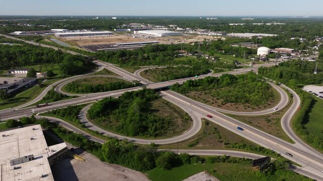 Aerial drone orbit of looping highway interchange with light traffic, drone